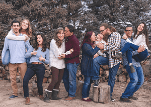 Family Taking a Picture In Front of a Wood Pile