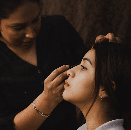 woman applying makeup to another woman (mobile beauty business image)