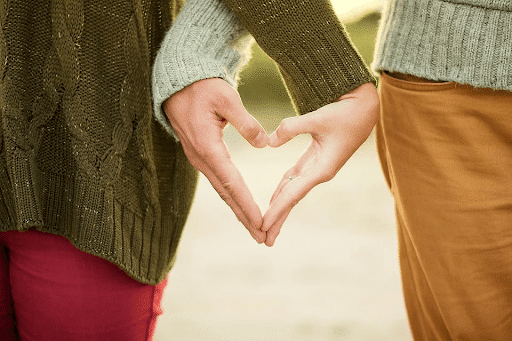 Young couple forming a heart with their hands