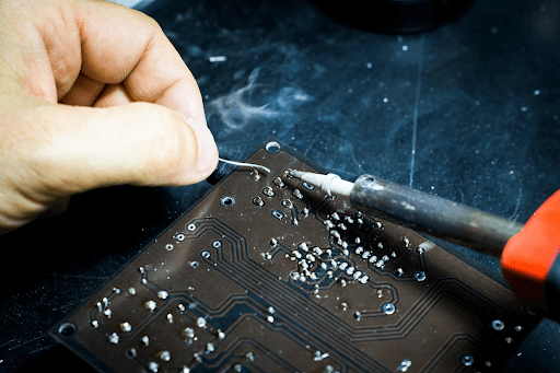  Hand of a person soldering a chip