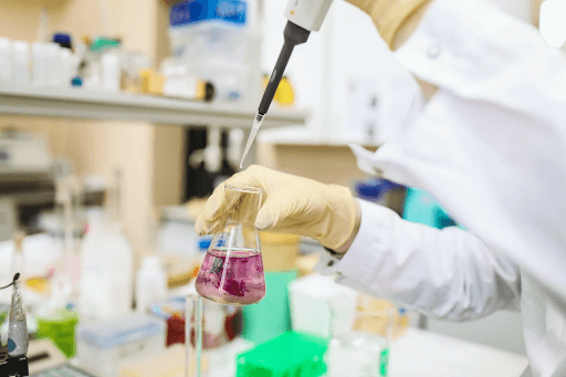 scientist holding a beaker in a laboratory (cosmetics manufacturing image)