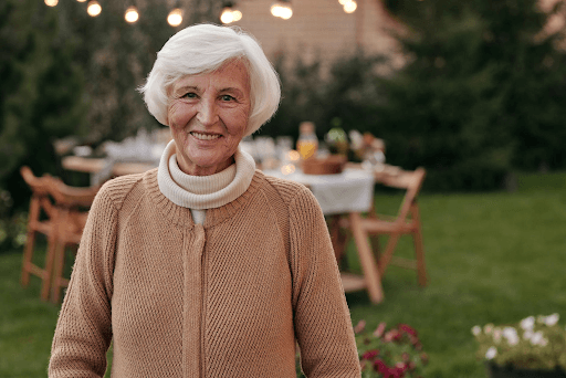 Cheerful smiling old woman in a backyard