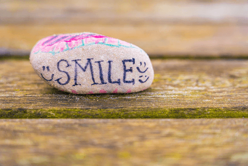 White and purple stone with the words SMILE written on it