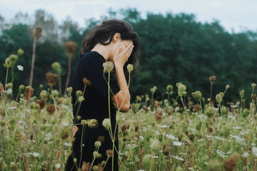 Woman standing while covering her face