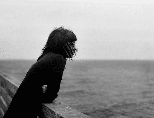 Black and white image of a woman watching the sea
