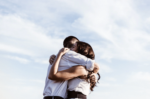 hugging couple with sky background