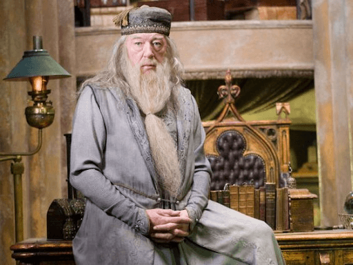 Dumbledore sitting on his table with fingers intertwined