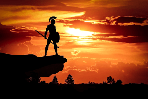 Silhouette of a Spartan warrior holding a shield and a spear at sun dusk