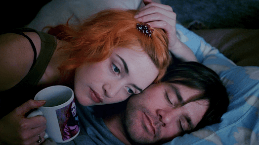 Clementine and Joel in a bed, with Clementine holding a cup