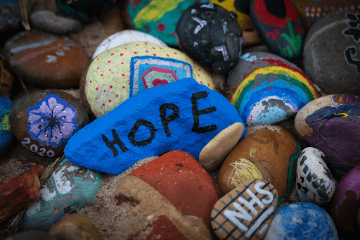 Painted rocks with ‘HOPE’ written on the blue rock in the middle 