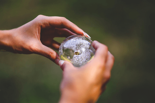 A person’s hands holding a clear crystal ball 