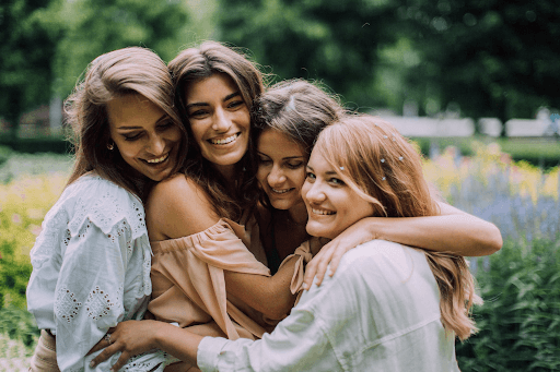 Four women hugging and smiling