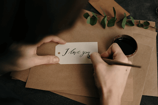 Man writing I love you on a piece of paper