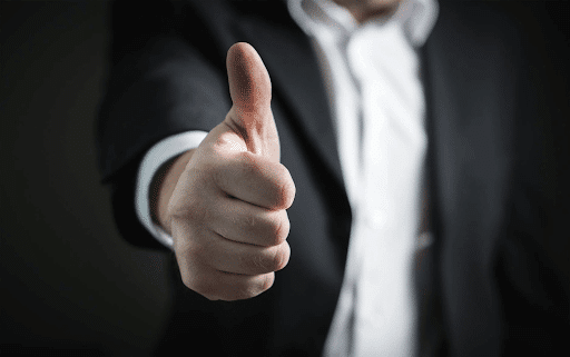 Close-up of a thumbs up hand of a man in a suit