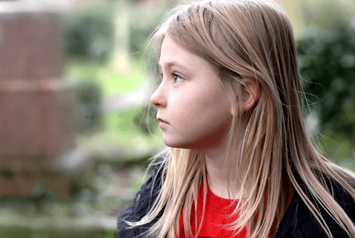 Side face photo of a blonde young girl looking to the left