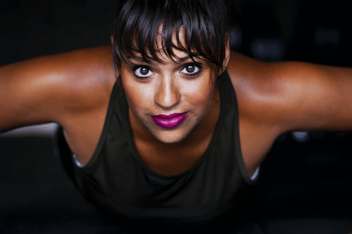 Smiling woman in a black tank top with arms spread out