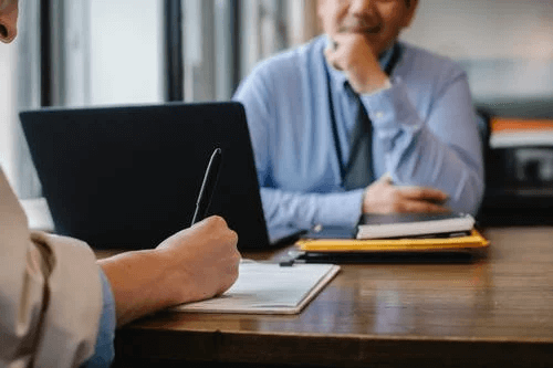 Woman Filing job Application Form in Office with Boss