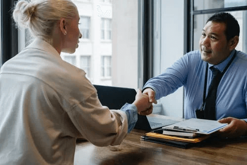  Businessman Shaking Hand of Applicant in Office