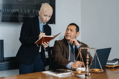  Diverse Serious Law Office Colleagues Taking Notes and Using Laptop