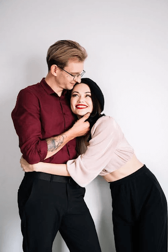  Woman in Pink Long Sleeve Shirt Hugging Man in Black Shirt