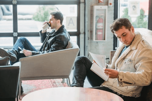 Young Entrepreneurs Working with Papers Drinking Coffee in Cafe