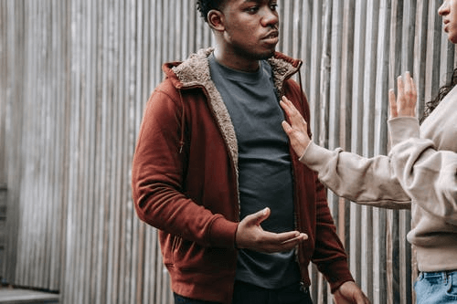 Crop Multiethnic Couple Arguing on Street 