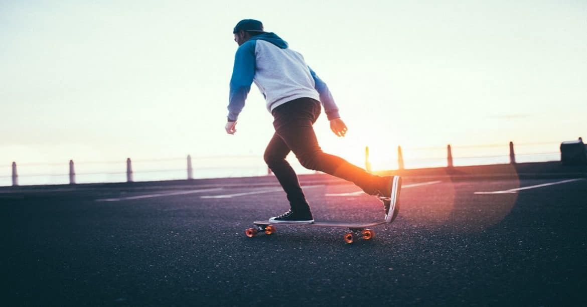 young-hipster-guy-longboarding-on-promenade-at-sunset_t20_RwvVvm
